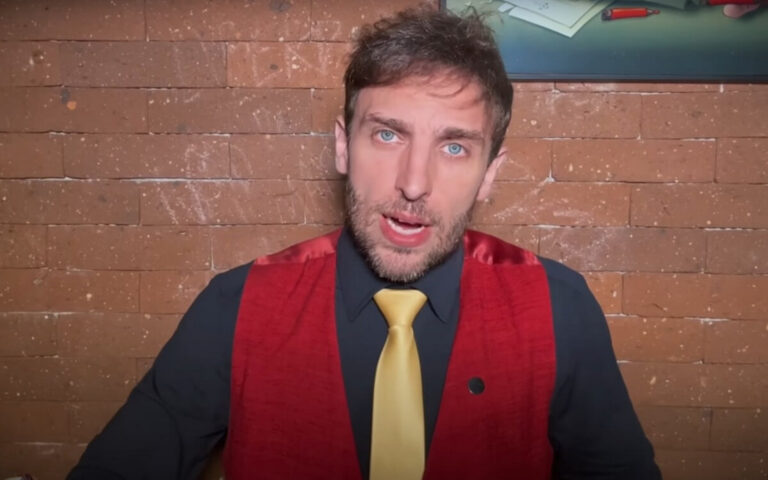 Léo Lins em foto de destaque, com colete vermelho e gravata amarela, em frente a uma parede de tijolos. Imagem representa o humorista Léo Lins no contexto da condenação e debate sobre limites do humor.
